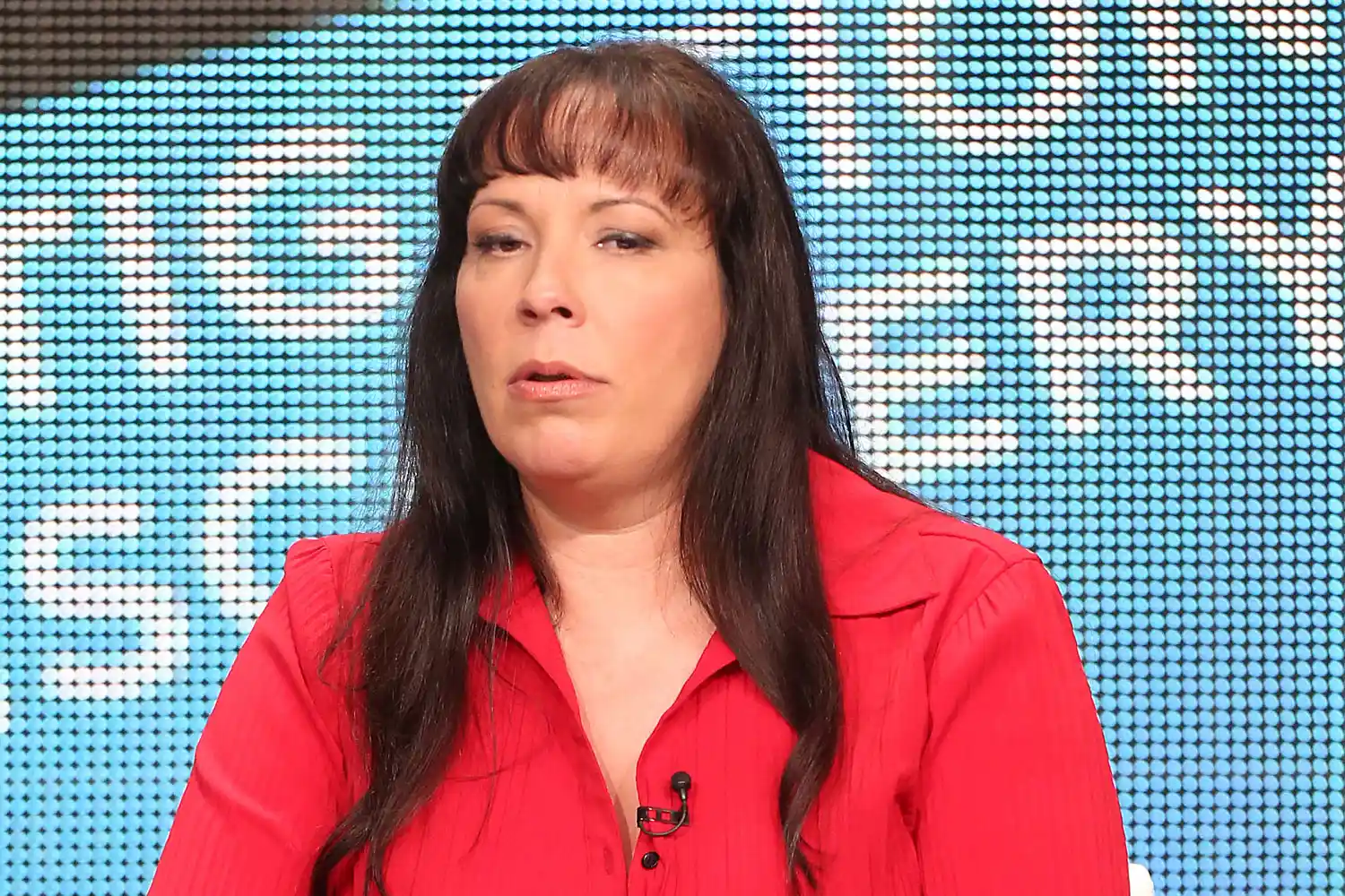 Survivor Lisa McVey speaking onstage at a crime panel event