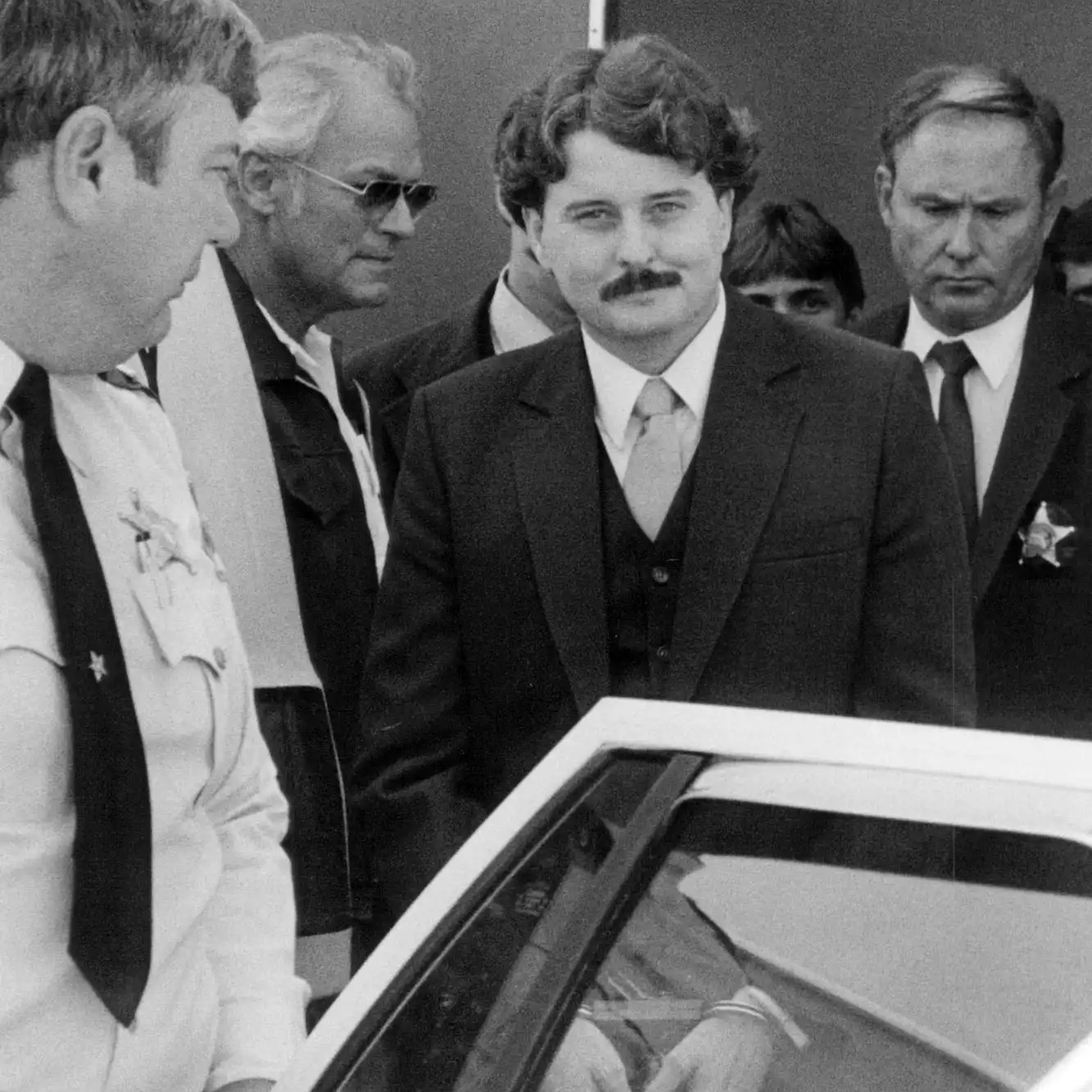 Bobby Joe Long is escorted by law enforcement officers during court proceedings arising from his 1984 crimes. - ZUMA Press Inc / Alamy Stock Photo via People